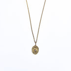 Collier long doré en acier inoxydable avec pendentif ovale soleil et oxyde de zirconium sur fond blanc