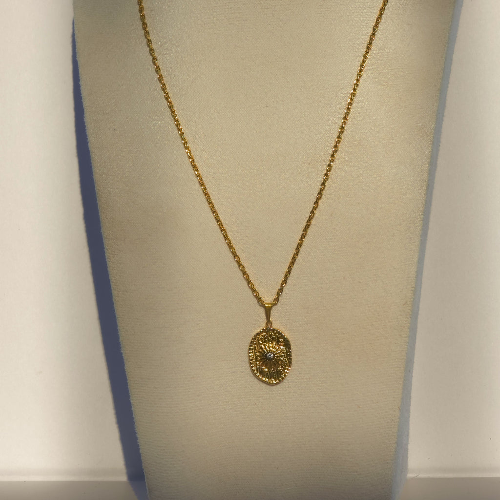 Collier long doré avec pendentif ovale soleil et oxyde de zirconium présenté sur buste