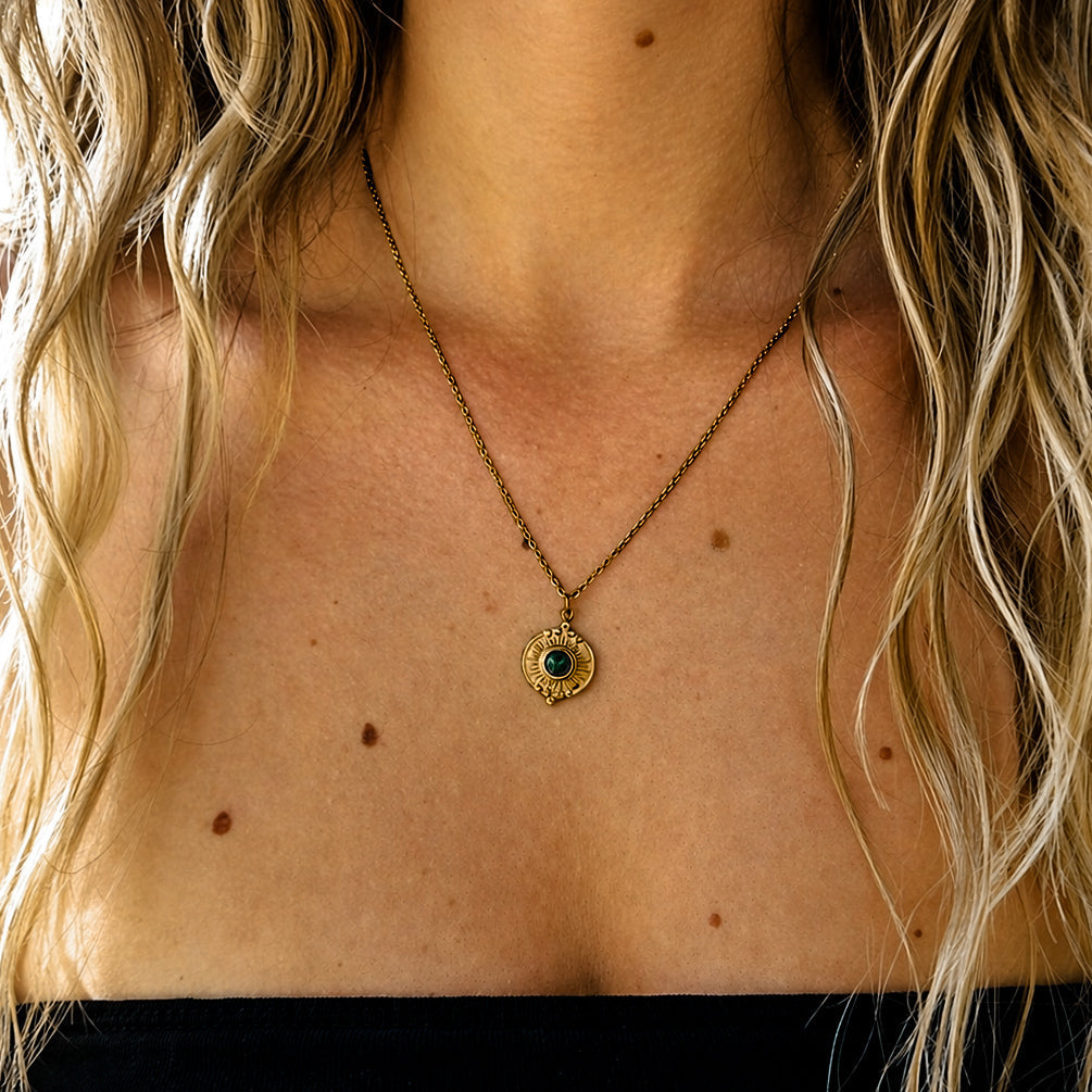 Collier doré en acier inoxydable porté avec pendentif solaire et malachite verte