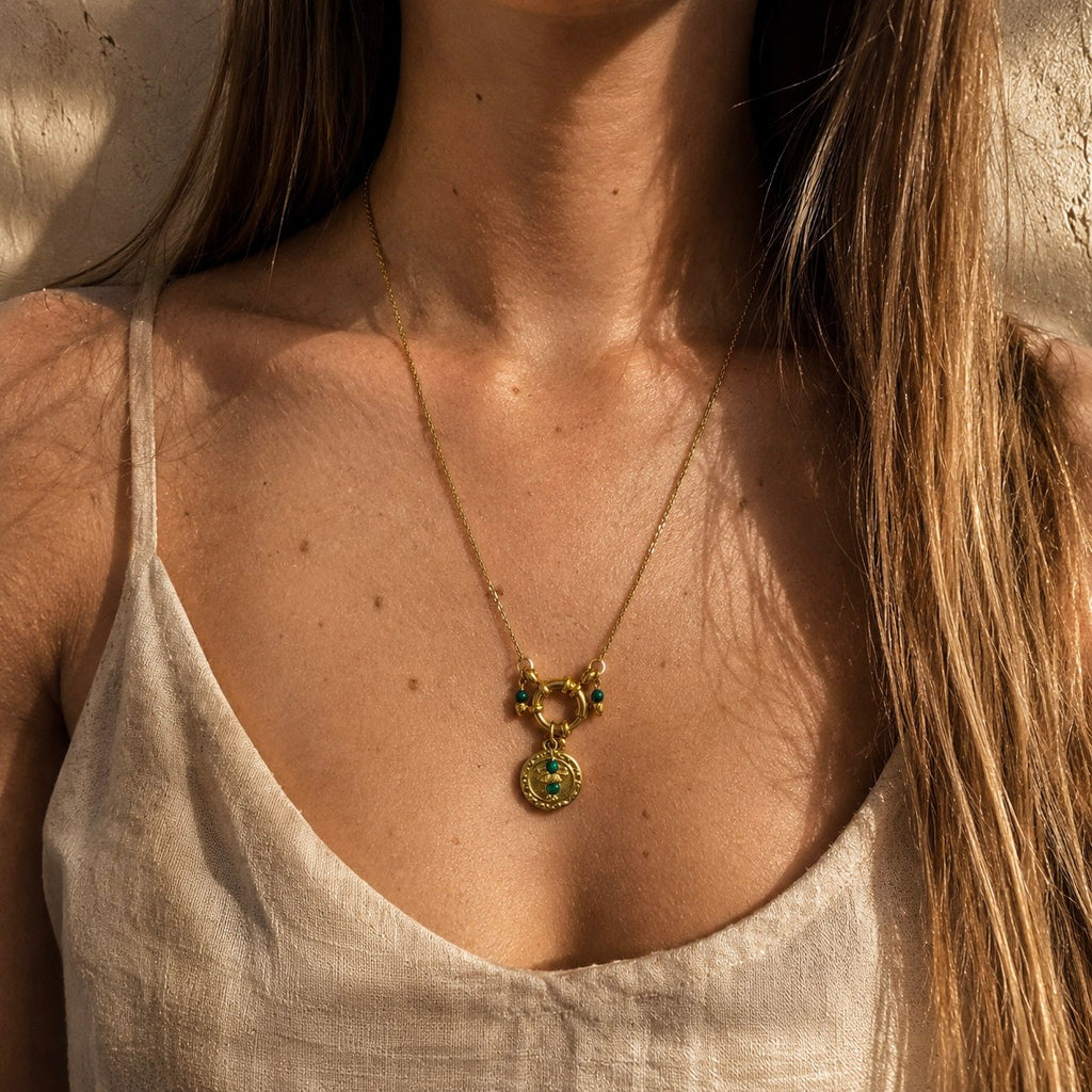 Collier doré porté avec pendentif oeil et perles de malachite vertes