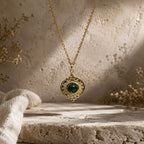 Détail d’un pendentif soleil doré avec pierre verte type malachite