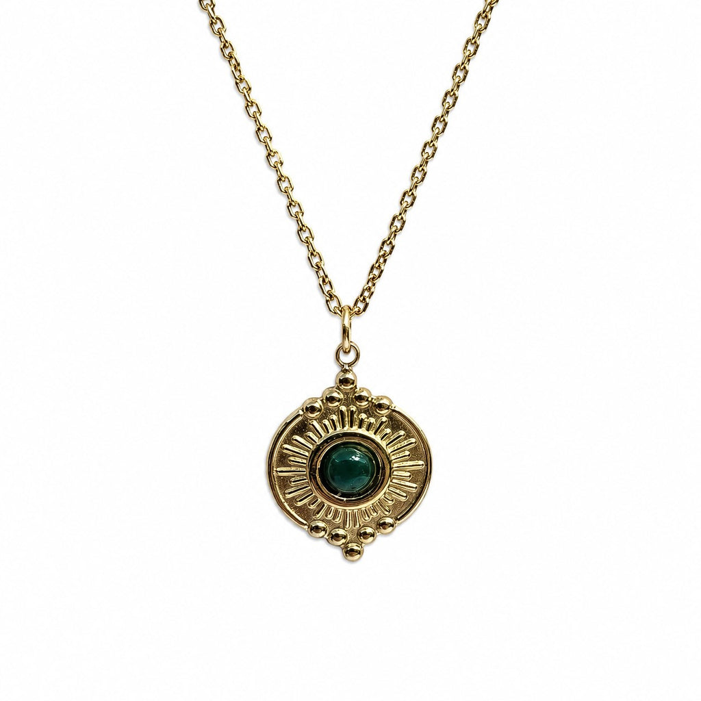 Collier doré avec pendentif soleil et pierre verte type malachite sur fond blanc