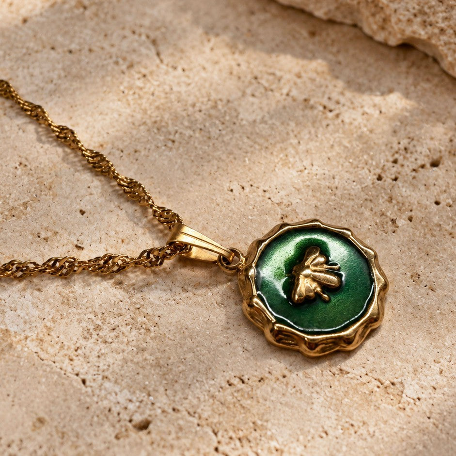 Détail du pendentif abeille vert en résine époxy sur chaîne dorée