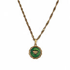 Collier doré avec pendentif abeille vert en résine époxy sur fond blanc