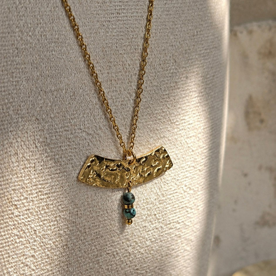 Détail du pendentif martelé du collier Moryn en acier inoxydable doré