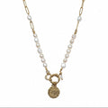 Collier femme en perles d’eau douce avec chaîne dorée, pendentif oeil et breloque lune sur fond blanc
