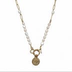 Collier femme en perles d’eau douce avec chaîne dorée, pendentif oeil et breloque lune sur fond blanc