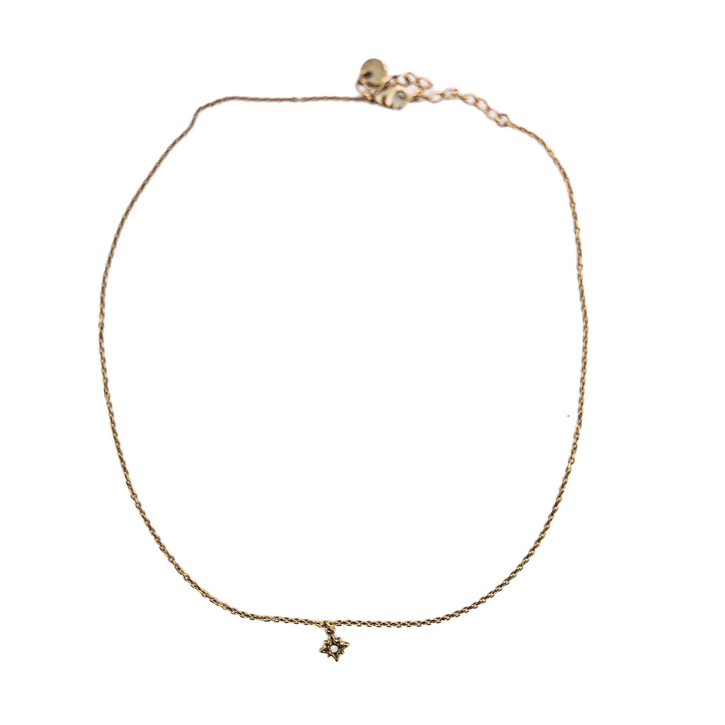 Collier ras de cou doré en acier inoxydable avec pendentif étoile du Nord et oxyde de zirconium sur fond blanc