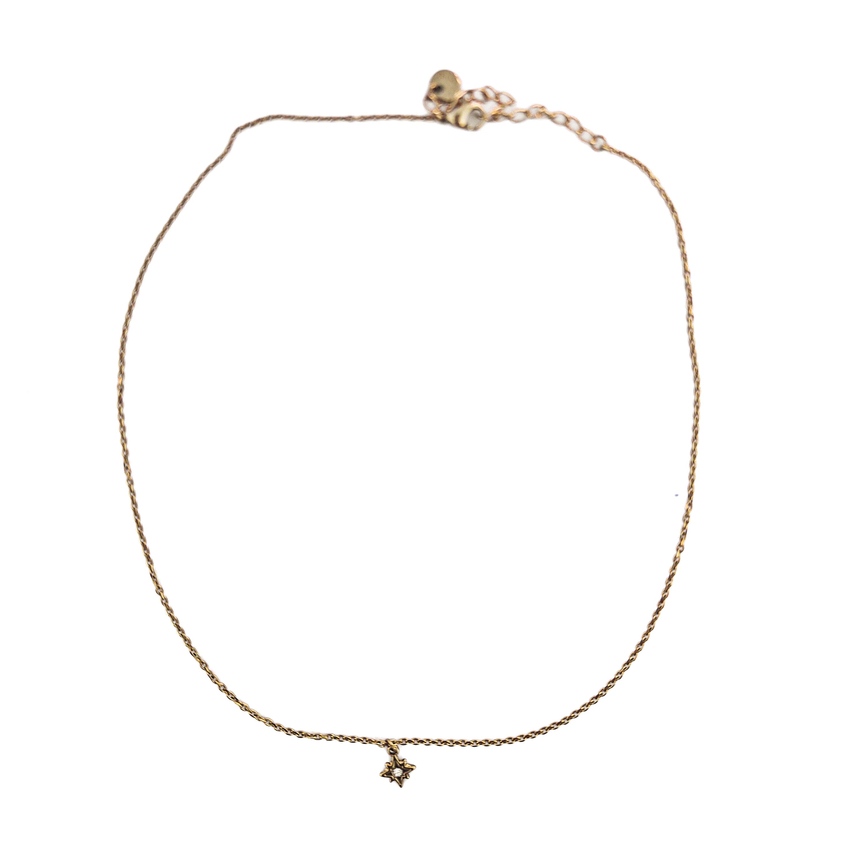 Collier ras de cou doré en acier inoxydable avec pendentif étoile du Nord et oxyde de zirconium sur fond blanc