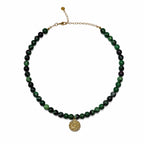 Collier en rubis zoïsite naturel avec médaille œil dorée sur fond blanc