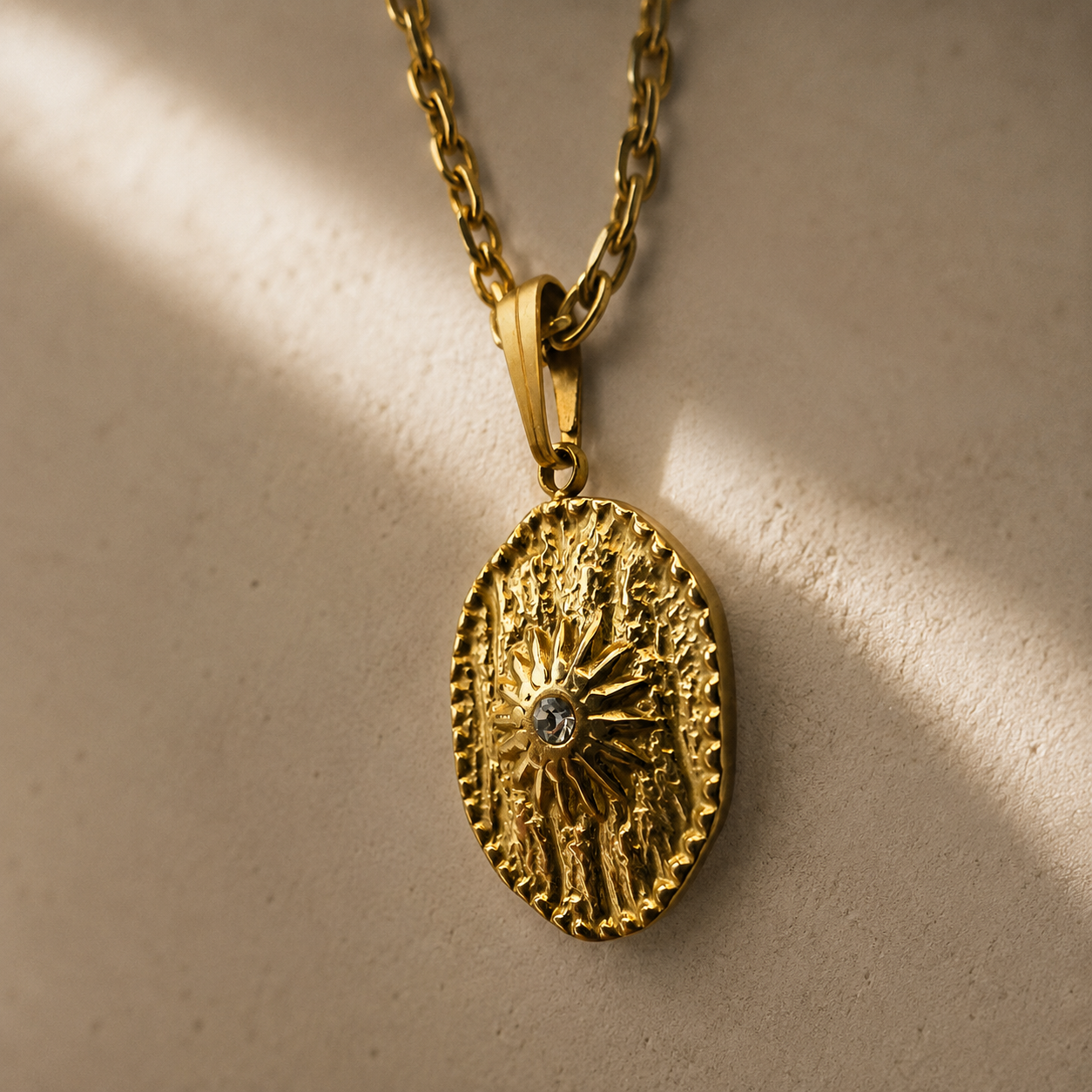 Collier  doré avec pendentif soleil texturé et strass centrale en gros plan