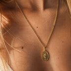 Collier  doré porté au cou avec pendentif soleil ovale