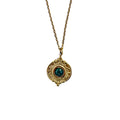 Gros plan sur un pendentif doré texturé avec malachite verte sur chaîne fine