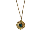 Gros plan sur un pendentif doré texturé avec malachite verte sur chaîne fine