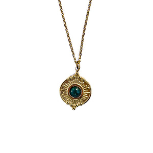 Gros plan sur un pendentif doré texturé avec malachite verte sur chaîne fine