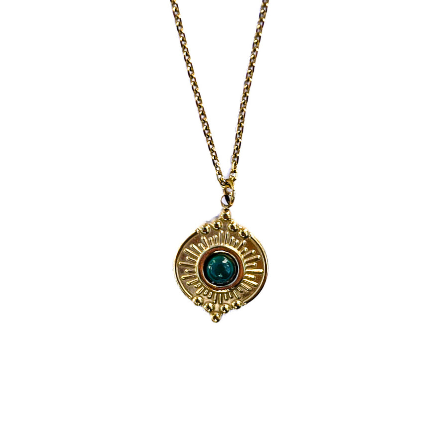 Gros plan sur un pendentif doré texturé avec malachite verte sur chaîne fine